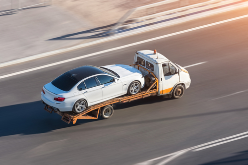 Recovery truck to transport a car on the highway in the city.