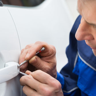 Close-up Of Person Hand Holding Lockpicker To Open Car Door